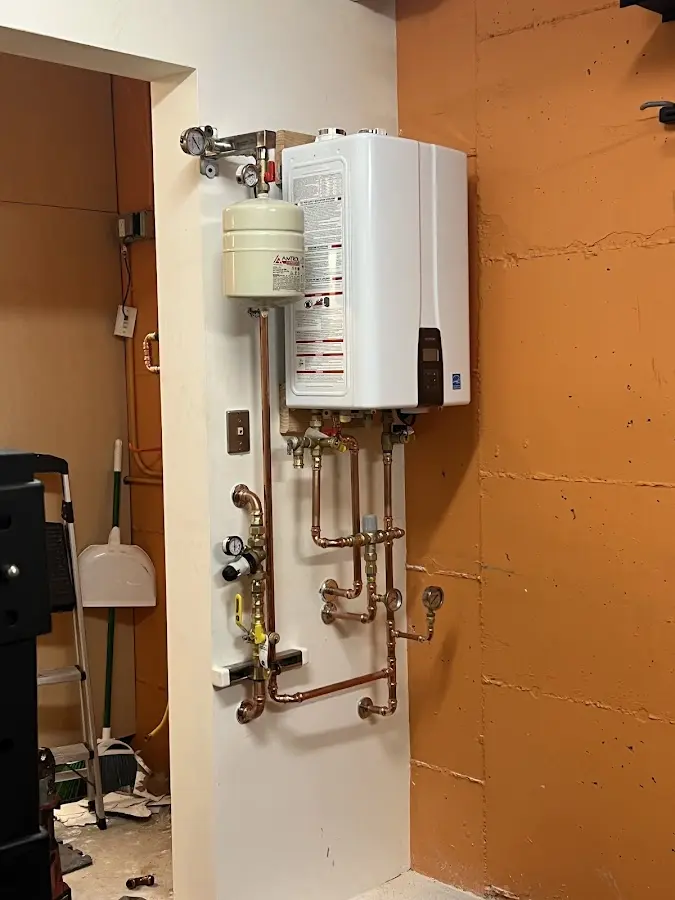 Plumbing technician inspecting water heater connections in Goodlettsville